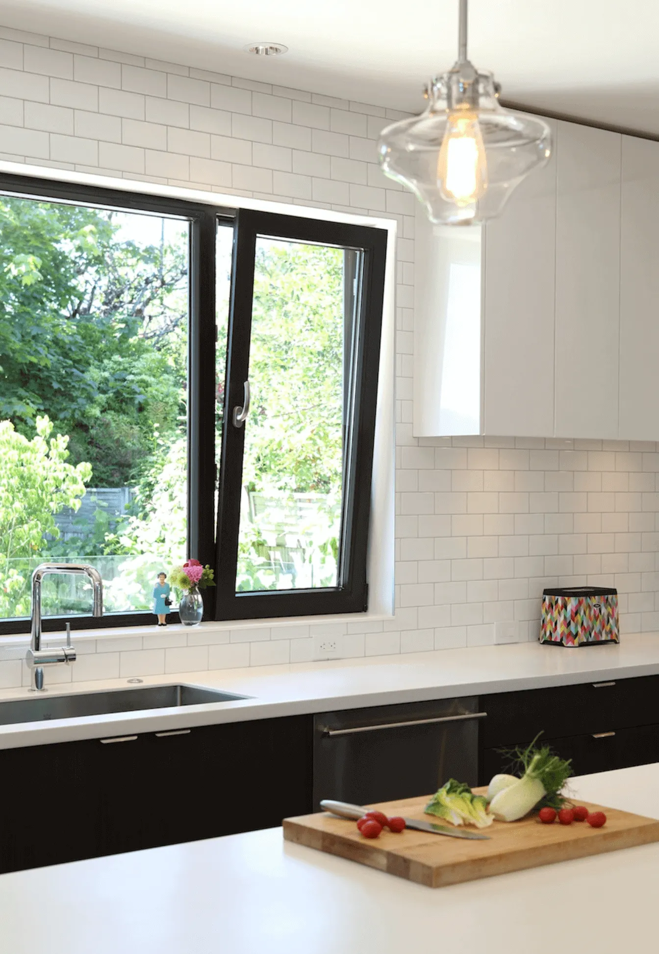 Black frame tilt and turn kitchen window above a sink in a bright modern kitchen